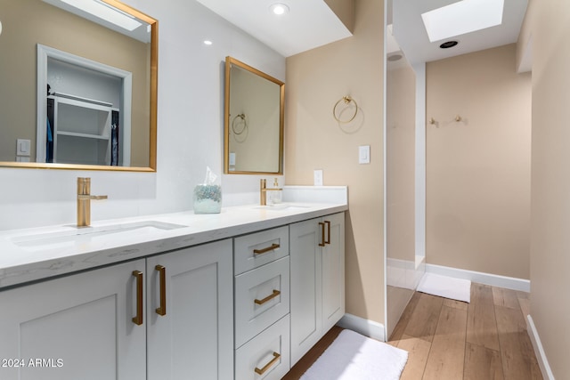 bathroom with vanity, wood-type flooring, and a skylight