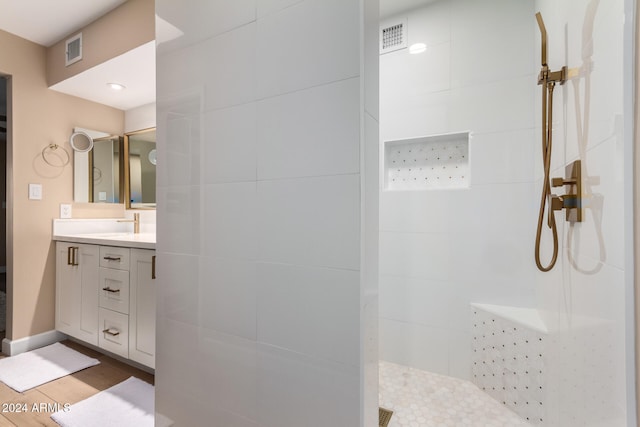 bathroom featuring vanity and tiled shower