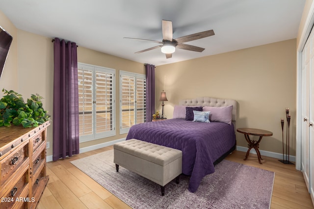 bedroom with a closet, light hardwood / wood-style floors, and ceiling fan