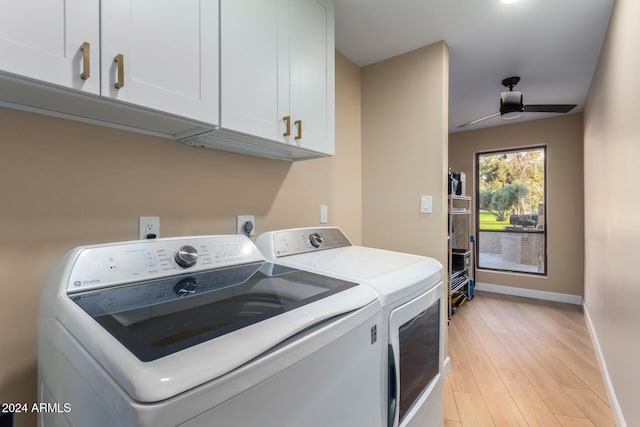 laundry room featuring ceiling fan, washer and clothes dryer, cabinets, and light hardwood / wood-style floors