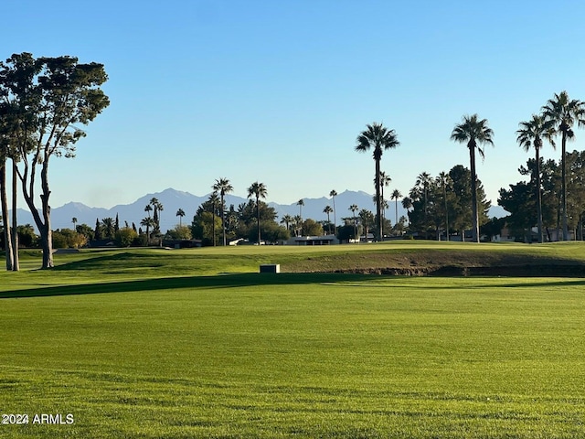 view of property's community with a mountain view and a lawn