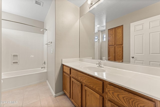 bathroom with tile patterned flooring, vanity,  shower combination, and a textured ceiling