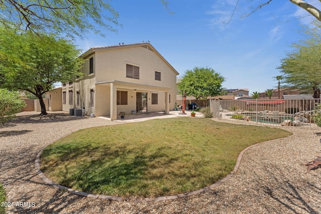 back of property featuring a yard, a patio, and cooling unit