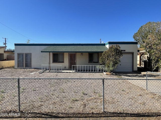 ranch-style house featuring a porch, an attached garage, driveway, and fence private yard