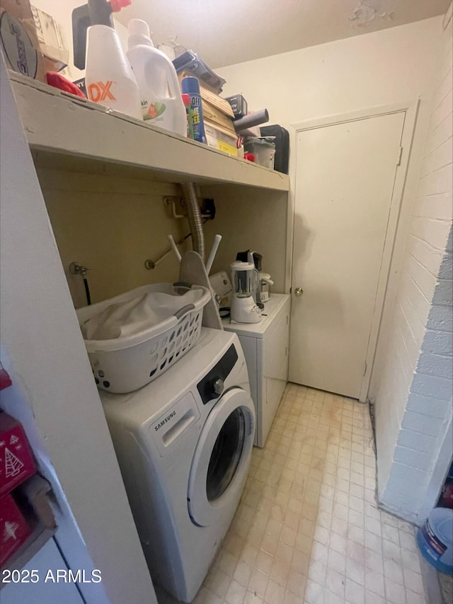 clothes washing area with light floors, laundry area, and independent washer and dryer