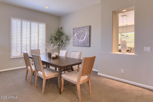 carpeted dining room with baseboards