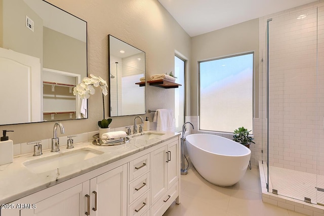 bathroom featuring a sink, a freestanding tub, a shower stall, and double vanity