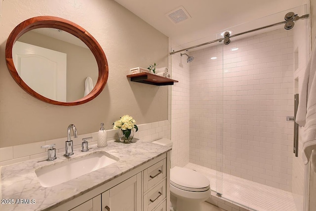 bathroom with visible vents, a stall shower, toilet, and vanity