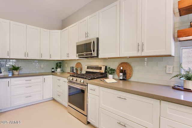 kitchen featuring appliances with stainless steel finishes, backsplash, and white cabinetry