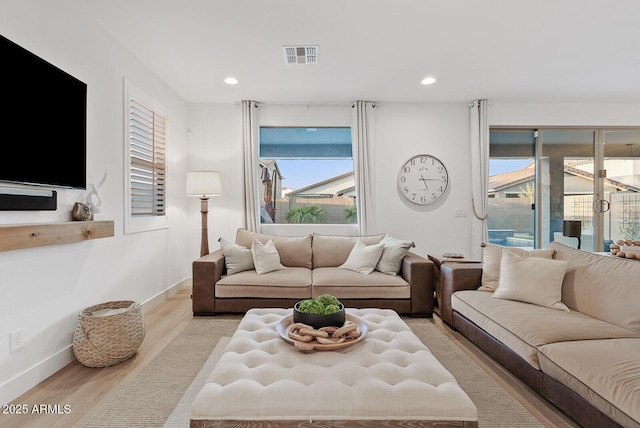 living room featuring plenty of natural light and light hardwood / wood-style floors