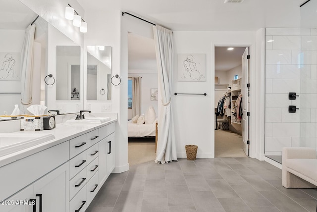 bathroom with tile patterned flooring, vanity, and a shower