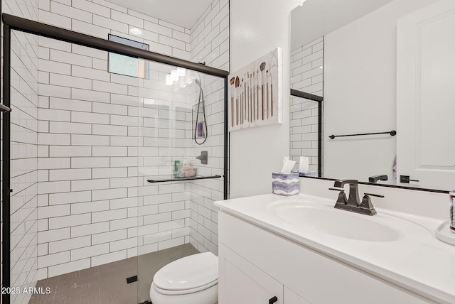 bathroom featuring vanity, toilet, and a shower with shower door