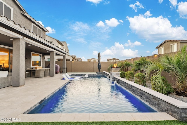 view of pool featuring grilling area, pool water feature, a patio, and an outdoor living space