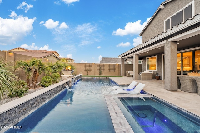 view of pool featuring pool water feature, outdoor lounge area, an in ground hot tub, and a patio