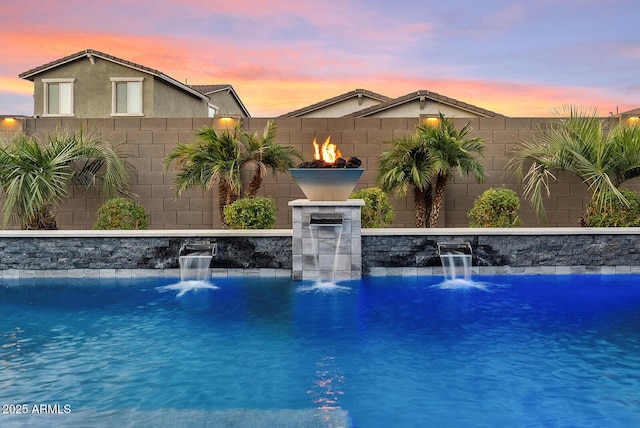 pool at dusk with pool water feature