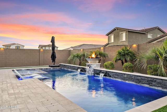 pool at dusk featuring pool water feature