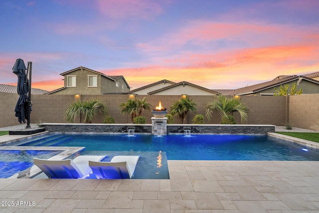 pool at dusk featuring pool water feature