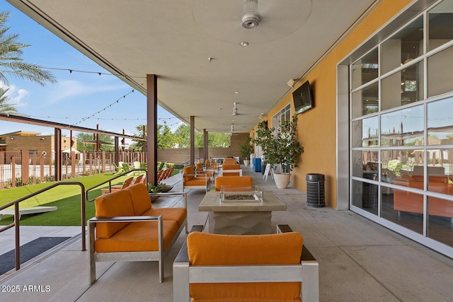 view of patio with an outdoor living space with a fire pit