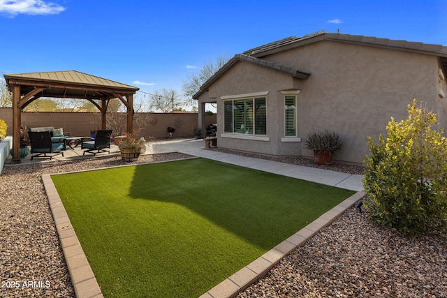 view of yard featuring outdoor lounge area, a gazebo, a fenced backyard, and a patio area