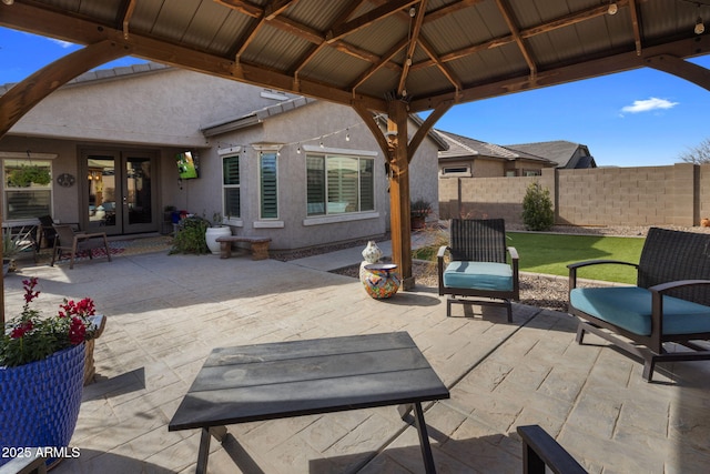 view of patio / terrace with fence, a gazebo, and french doors