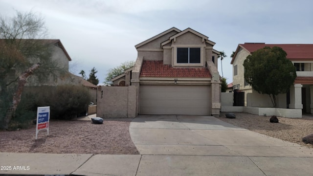 view of front facade featuring a garage, a tiled roof, concrete driveway, and stucco siding