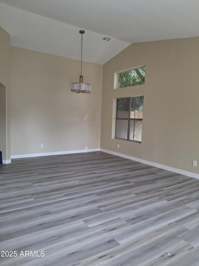 empty room with lofted ceiling and hardwood / wood-style floors