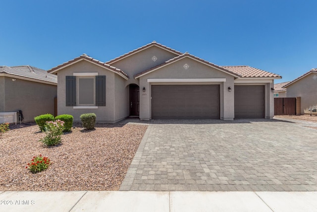17973 W Ashley Dr, Goodyear, AZ 85338 - view of front of house featuring an attached garage, decorative driveway, stucco siding, and a tiled roof