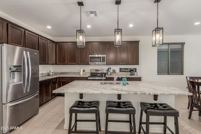 17973 W Ashley Dr, Goodyear, AZ 85338 - kitchen featuring appliances with stainless steel finishes, a sink, dark brown cabinetry, pendant lighting, and recessed lighting