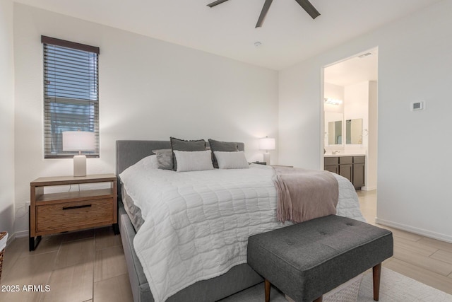17973 W Ashley Dr, Goodyear, AZ 85338 - bedroom with light wood finished floors, baseboards, ensuite bath, and ceiling fan