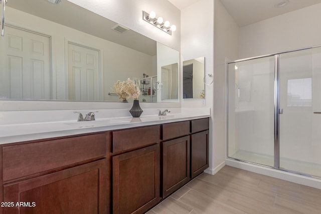 17973 W Ashley Dr, Goodyear, AZ 85338 - full bathroom featuring double vanity, a stall shower, and wood finished floors
