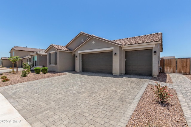 17973 W Ashley Dr, Goodyear, AZ 85338 - view of front facade with decorative driveway, stucco siding, a garage, and a tiled roof
