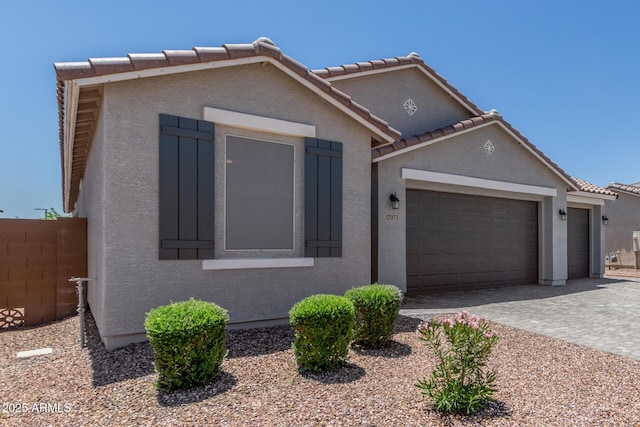 17973 W Ashley Dr, Goodyear, AZ 85338 - view of front facade featuring a garage, stucco siding, decorative driveway, and a tile roof