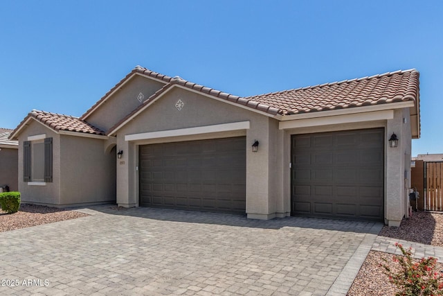 17973 W Ashley Dr, Goodyear, AZ 85338 - mediterranean / spanish home featuring a garage, decorative driveway, a tiled roof, and stucco siding