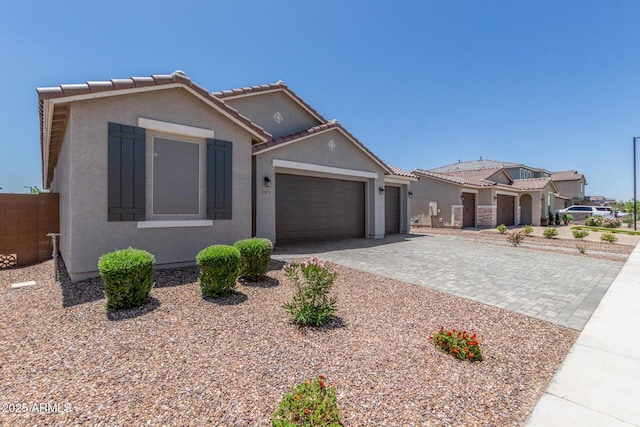 17973 W Ashley Dr, Goodyear, AZ 85338 - view of front of home featuring a garage, decorative driveway, stucco siding, and a tiled roof