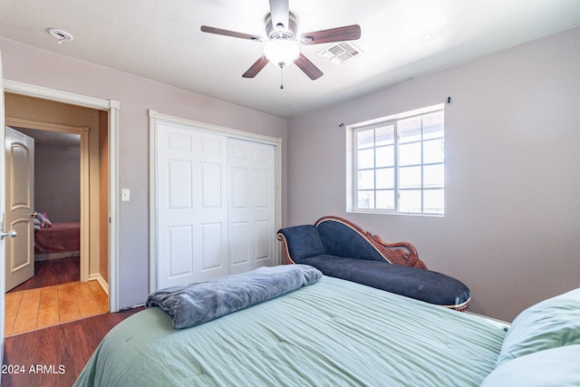 bedroom with a closet, ceiling fan, and dark hardwood / wood-style floors