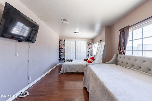 bedroom featuring lofted ceiling, a closet, and dark hardwood / wood-style floors