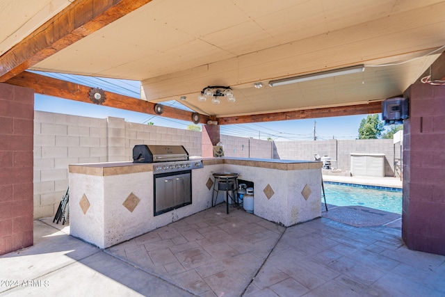 view of patio / terrace featuring a fenced in pool and exterior kitchen