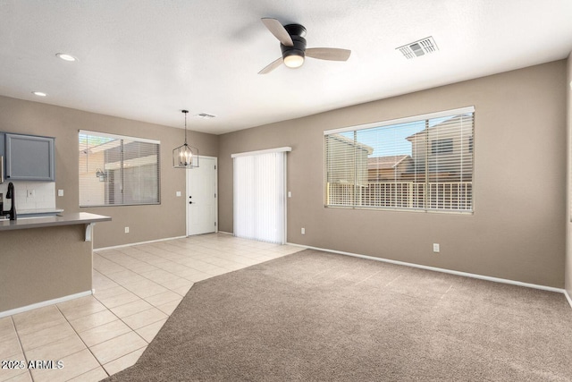 8795 W Windsor Dr, Peoria, AZ 85381 - unfurnished living room featuring ceiling fan, light tile patterned floors, baseboards, recessed lighting, and a chandelier