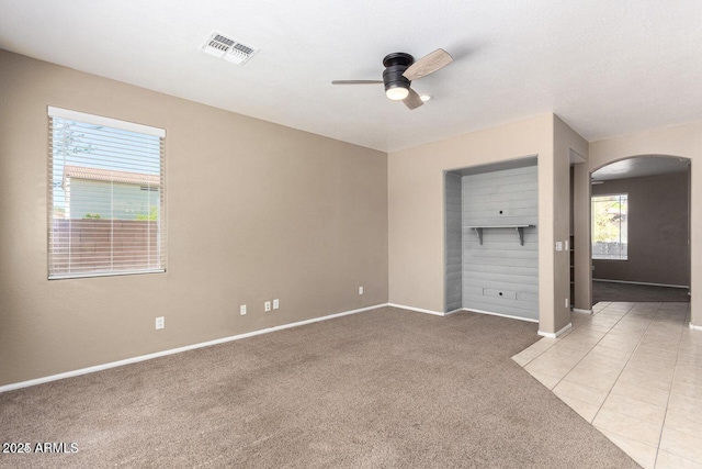8795 W Windsor Dr, Peoria, AZ 85381 - empty room featuring arched walkways, ceiling fan, light colored carpet, and baseboards