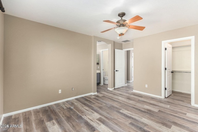 8795 W Windsor Dr, Peoria, AZ 85381 - unfurnished bedroom with arched walkways, wood finished floors, and baseboards
