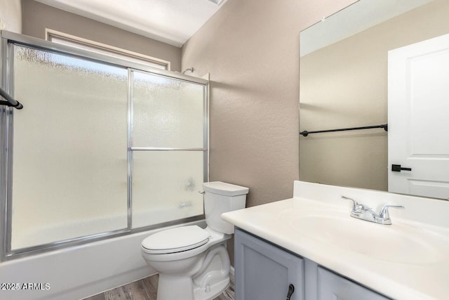 8795 W Windsor Dr, Peoria, AZ 85381 - full bathroom with wood finished floors, toilet, vanity, and bath / shower combo with glass door