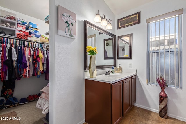 10465 W Windsor Blvd, Glendale, AZ 85307 - bathroom featuring vanity, a walk in closet, baseboards, and tile patterned floors