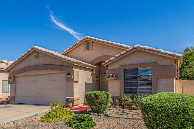 10465 W Windsor Blvd, Glendale, AZ 85307 - mediterranean / spanish house featuring an attached garage, stucco siding, concrete driveway, and a tiled roof