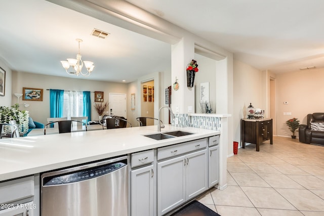 kitchen featuring sink, decorative light fixtures, a chandelier, light tile patterned floors, and dishwasher