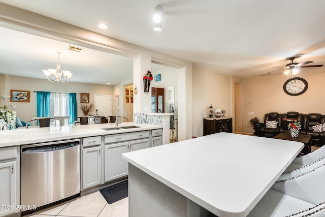 kitchen featuring sink, a kitchen island, a kitchen bar, decorative light fixtures, and stainless steel dishwasher