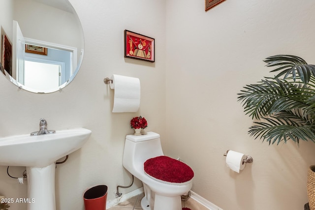 bathroom with sink, toilet, and tile patterned flooring