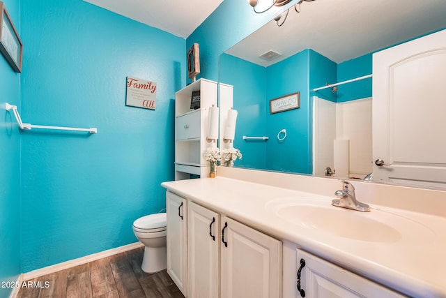 bathroom with vanity, hardwood / wood-style flooring, a shower, and toilet