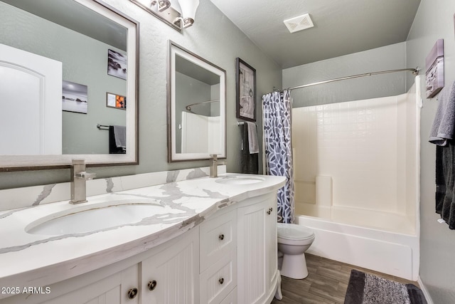 full bathroom featuring vanity, wood-type flooring, shower / tub combo, and toilet