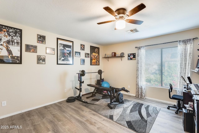 workout area featuring ceiling fan, a textured ceiling, and light hardwood / wood-style floors