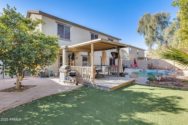 back of house with a fenced in pool, a lawn, and a patio